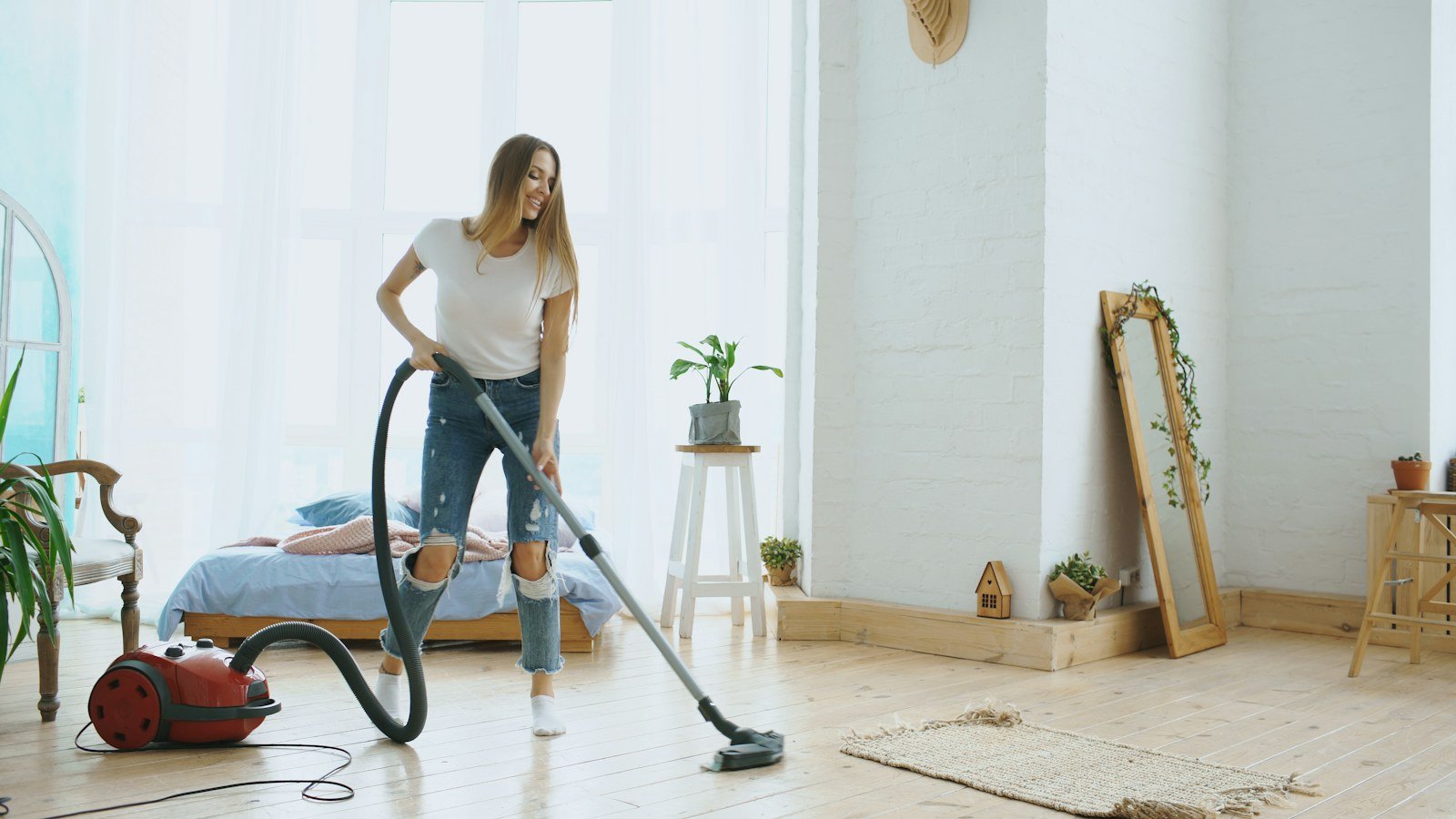 Person vacuuming a bright modern living room