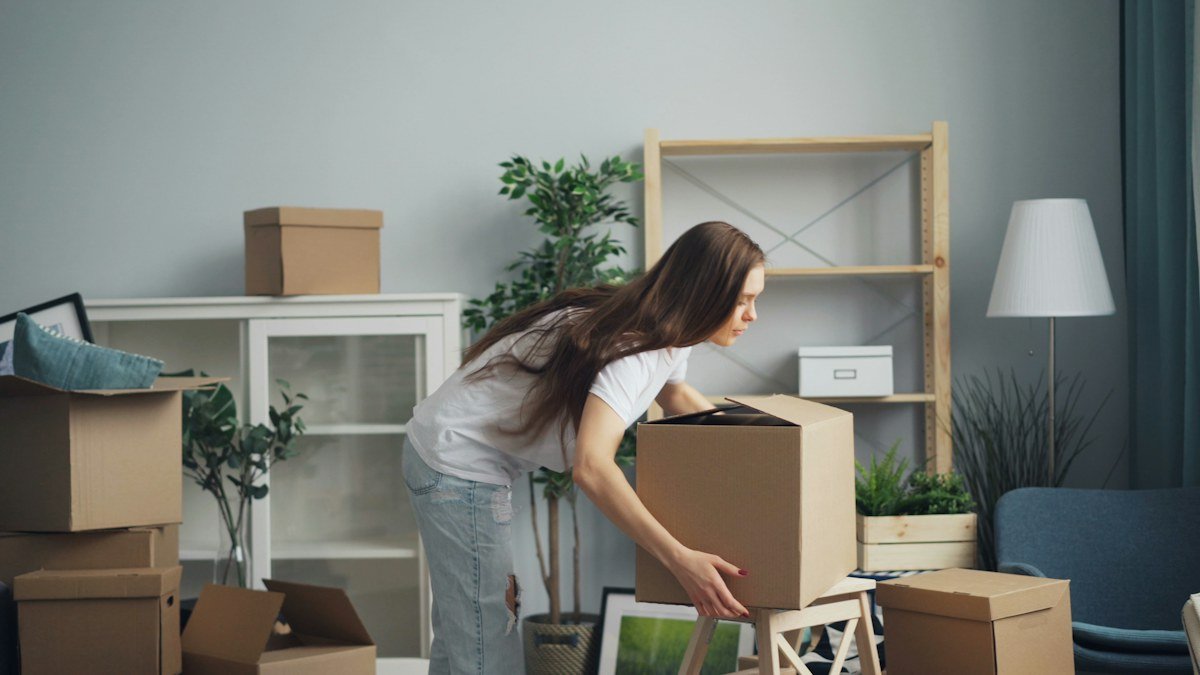 Woman moving boxes in a living room